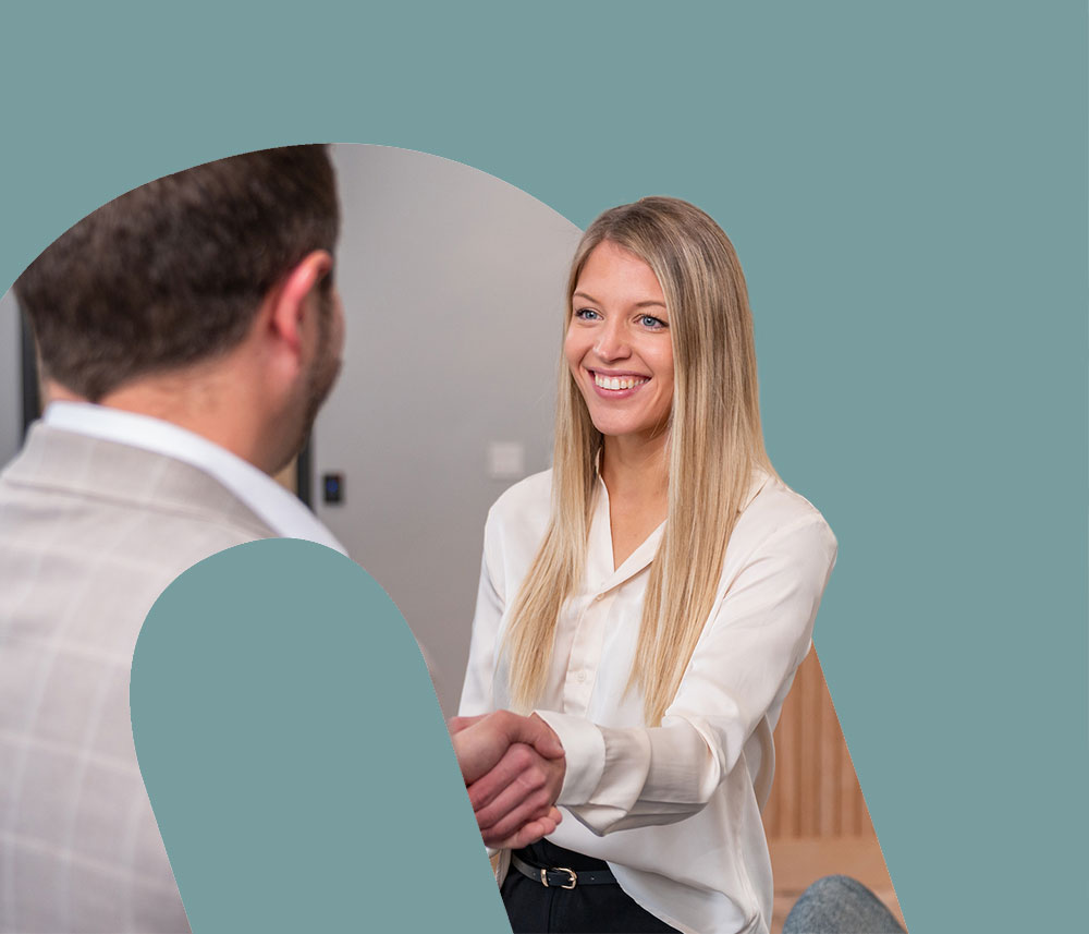 In a cutout of the Honkamp logo, a blonde woman shakes the hand of a man facing away from the camera